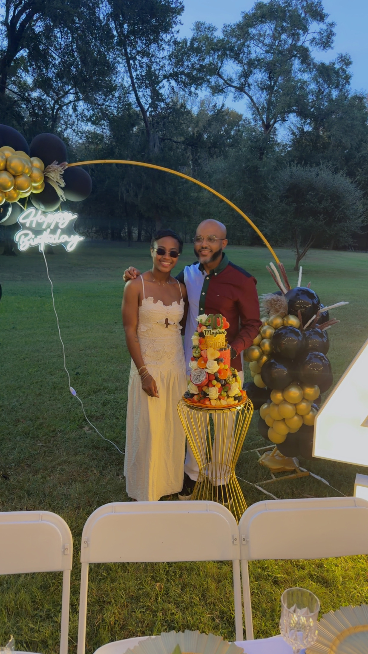 Guests beside birthday cake and balloon installation
